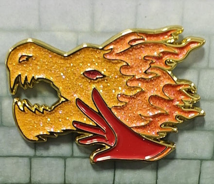 A beautiful red and orange pin depicting a hand conjuring a fiery dragon, a representation of the Sorcerer D&D class.
